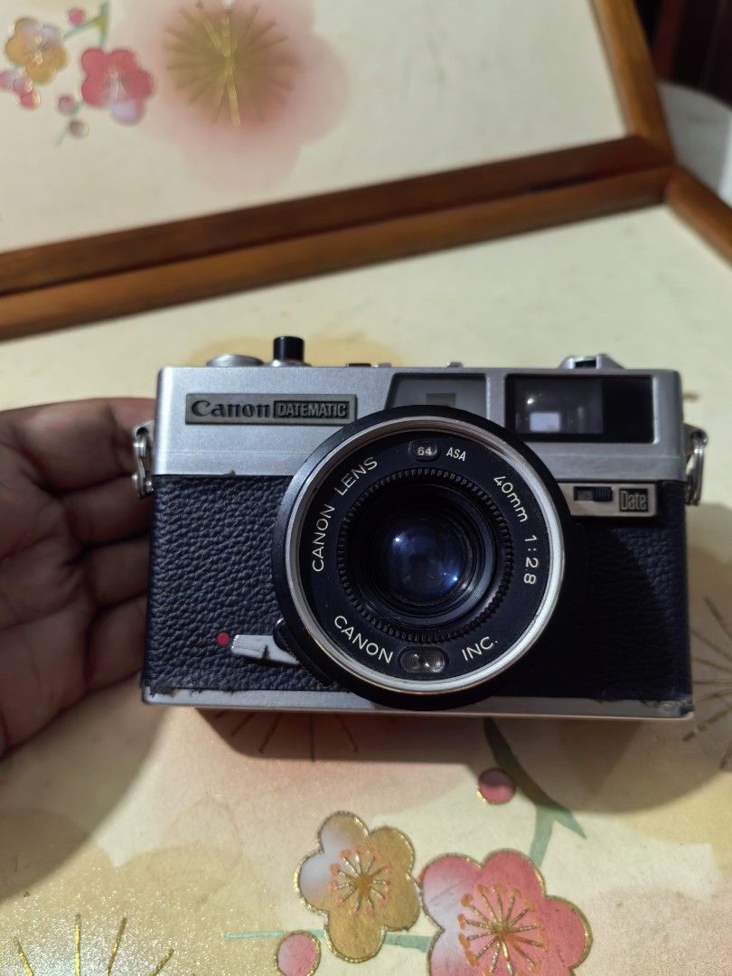 Canon Datematic Camera (Category: Cameras) located in Cebu City. Submitted by dudes_villanueva (Listing ID 1389558824, Image 1). Description: Canon Datematic Note: Not Working. Film Lever stuck. Foam Seal brittle. Rangefinder has tiny dust. Camera Lens on good condition. Sold as is. All sales final and Non-refundable. 📌A compact 35mm rangefinder camera released in 1974. 📌It features programmed autoexposure and a 40mm f/2.8 lens. 📌A key feature