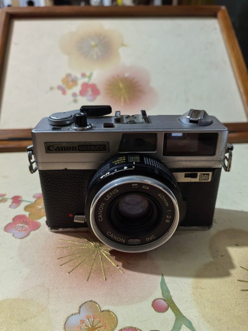 Canon Datematic Camera (Category: Cameras) located in Cebu City. Submitted by dudes_villanueva (Listing ID 1389558824, Image 2). Description: Canon Datematic Note: Not Working. Film Lever stuck. Foam Seal brittle. Rangefinder has tiny dust. Camera Lens on good condition. Sold as is. All sales final and Non-refundable. 📌A compact 35mm rangefinder camera released in 1974. 📌It features programmed autoexposure and a 40mm f/2.8 lens. 📌A key feature