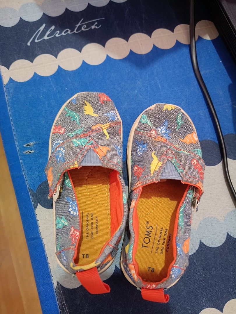 PreLoved Toms Slip on Shoes (Category: Babies & Kids Fashion) located in Paranaque City. Submitted by mscath.varietyshop (Listing ID 1384492656, Image 1). Description: WYSIWYG just needs cleaning RFS: outgrown design: dinosaurs size: US8 / 15CM.