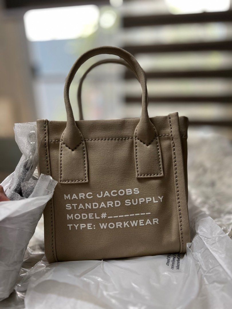 MARC JACOBs Canvas tote (small) (Category: Cross-body Bags) located in Cavite. Submitted by everythingnicehere (Listing ID 1389737758, Image 3). Description: ✨ Condition: 100% Brand New, Never Used ✨ Authenticity: Imported from the US (Original Marc Jacobs) 💯 ✨ Color: Beige ✨ Size: Small Tote ✨ Material: Canvas SIZE & FIT L:20.5cm W:12cm H:22.5cm Handle Drop: 10.5cm Crossbody/ Top Handle Bag Printed Logo on Front Top Zip Closure Removable & Adju