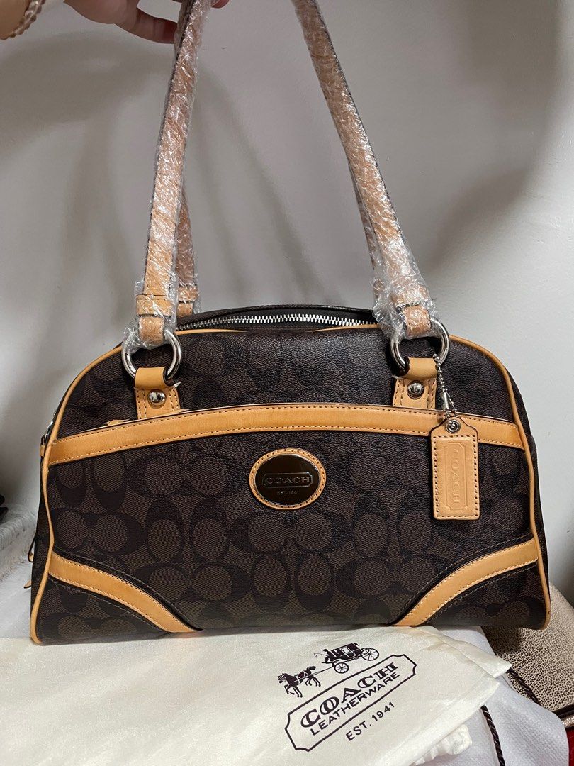 Authentic Coach Signature Heritage Boston (Category: Luxury Bags & Wallets) located in Guiguinto. Submitted by prelovedinc2024 (Listing ID 1389852832, Image 1). Description: guaranteed authentic, bought in Japan with signs of use - discoloration/oxidation on some parts, rubs/dirt on corners, some scratches on silver hardwares no cracks comes with dustbag size: 12x8x6”.