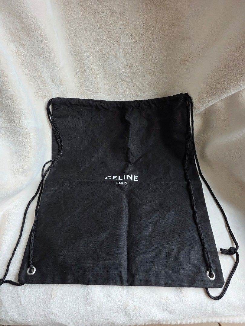 Celine drawstring back pack (Category: Backpacks) located in Singapore. Submitted by citronpresseaufrais (Listing ID 1389879807, Image 2). Description: Celine Drawstring Backpack – Black Canvas with Logo Print Casual yet chic, this Celine drawstring backpack is crafted from durable black canvas and features the CELINE PARIS logo in contrasting white. Lightweight and versatile, it can be worn as a backpack with the rope drawstring straps or carrie