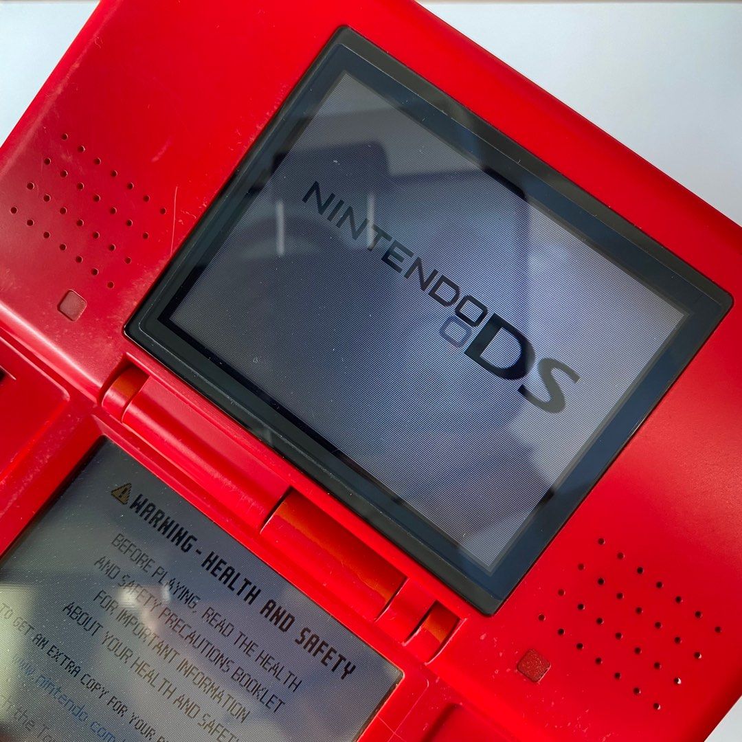 Original Nintendo DS (Phat) – Red (Category: Nintendo) located in Pasig City. Submitted by mark_cedrick (Listing ID 1389876682, Image 3). Description: Classic red Nintendo DS “Phat” model in working condition. Shows some discoloration from age and surface scratches from normal use. Top screen still has its original screen protector. Includes original stylus (slightly bent) but still usable. 🎮 Fully functional 🟥 Red shell with visible aging/disc