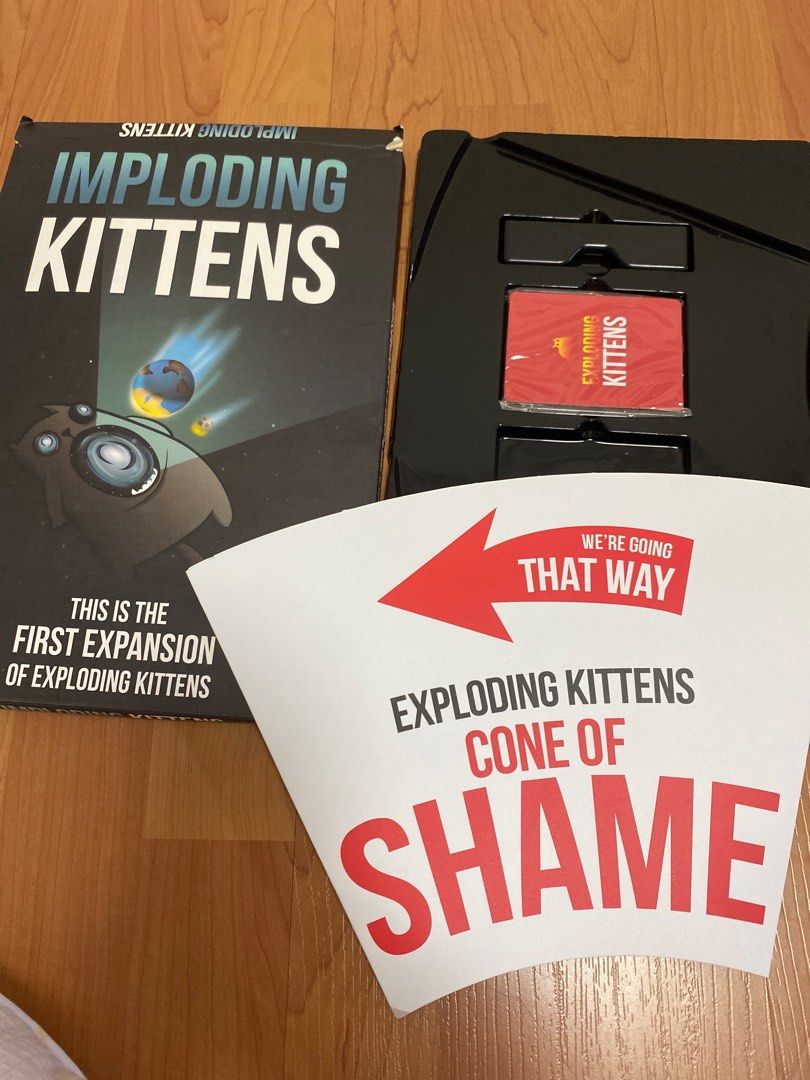 Imploding Kittens Expansion Pack for Exploding Kittens (Category: Board Games & Puzzles) located in Singapore. Submitted by lynramosp (Listing ID 1384773808, Image 3). Description: - Imploding Kittens expansion pack for Exploding Kittens. - Includes 20 new cards illustrated by The Oatmeal. - Adds support for a 6th player. - Features a human-sized Cone of Shame turn indicator. - Suitable for ages 7+..