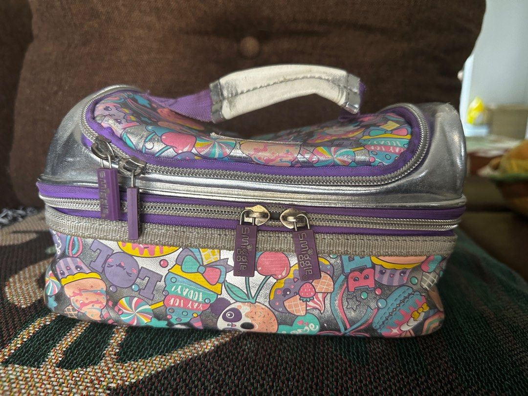 Smiggle Insulated Lunch Bag - 2 layers (Category: Food Organization & Storage) located in Cavite. Submitted by flyfly_butterfly (Listing ID 1384665311, Image 3). Description: Smiggle Insulated Lunch Bag - 2 layers Print: mettalic silver Insulated layers intact Zipper working Handle: faded due to usage Dasmariñas Cavite location Jnt or lalamove shipping.
