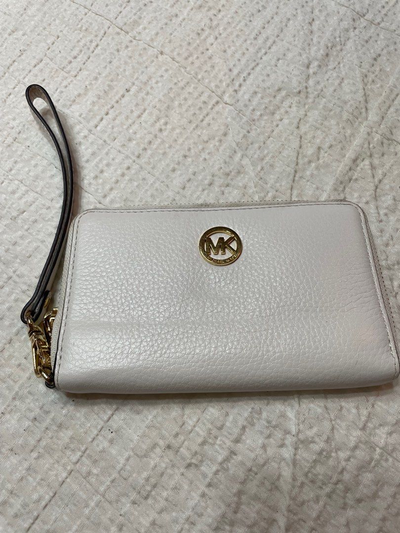 Michael Kors White Wristlet (Category: Luxury Bags & Wallets) located in Taguig. Submitted by uppcyclee (Listing ID 1385388956, Image 1). Description: Slightly used, needs a bit of cleaning see pics for reference. Overall, still in great condition MOP: GCash, Bank Transfer within BPI, BDO, CIMB 📍Taguig City / SJDM, Bulacan 🚗Lalamove / J&T / GrabExpress.