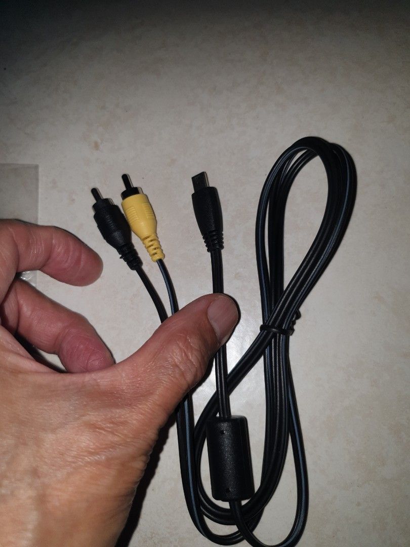Camera audio cable (Category: Cables & Adaptors) located in Singapore. Submitted by sengkang-ranggung (Listing ID 1390049698, Image 2). Description: The cable has a mini-USB connector on one end and yellow/black RCA connectors on the other. Free mailing possible. No refund after buying for whatever reason. $8.80 nett. pick up Ranggung lrt, Sengkang mrt..