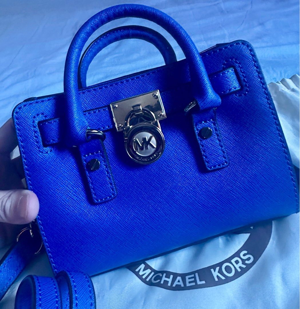 Michael Kors Micro Hamilton Bag (Category: Luxury Bags & Wallets) located in Quezon City. Submitted by tiffngo_cheng (Listing ID 1391809713, Image 2). Description: Never used - bought & kept Color - Royal Blue With dust bag This bag is part of the iconic Hamilton collection by Michael Kors. It features a belted silhouette with a polished padlock charm and gold-tone hardware. Crafted from high-quality leather, it offers both durability and a luxur