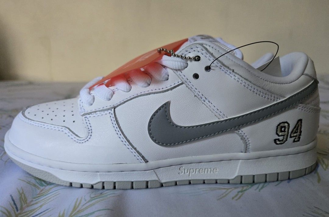 Supreme x Nike SB Dunk Low (Category: Sneakers) located in Makati City. Submitted by olaxb (Listing ID 1392011060, Image 3). Description: - Supreme x Nike SB Dunk Low OG QS - White and grey colorway - Size 6.5 - Brand new, never worn - Comes with original box and tags.