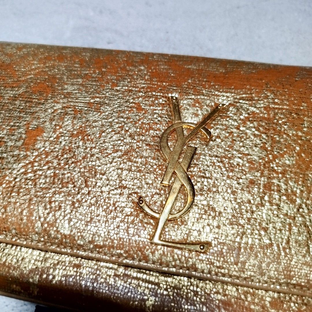YSL Sac Cassandre Bag ✨ (Category: Luxury Bags & Wallets) located in Manila. Submitted by mnlhappybattle (Listing ID 1392087177, Image 3). Description: YSL Sac Cassandre Bag ✨ Authentic Saint Laurent Paris clutch in metallic gold. Condition: Minimal color issue as seen in photos, but still very presentable and stylish — the wear even adds unique character to the bag. Inclusions: With authenticity cards (no dust bag). Timeless piece that elevates 