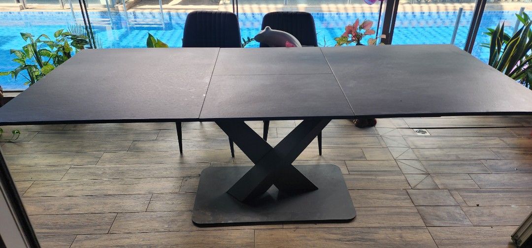 Extendable Dining Table (Category: Tables & Sets) located in Singapore. Submitted by seantanls (Listing ID 1392507782, Image 1). Description: - Stylish black dining table - Modern, contemporary design - Unique X-shaped base for stability - Durable tabletop - Ideal for family meals and entertaining guests -pull out to seat even more guest. -table is a bit of warped on a few edges due to moisture. -arrange your own delivery.