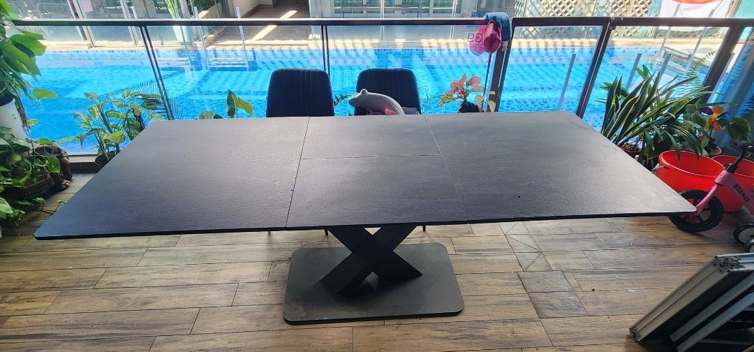 Extendable Dining Table (Category: Tables & Sets) located in Singapore. Submitted by seantanls (Listing ID 1392507782, Image 3). Description: - Stylish black dining table - Modern, contemporary design - Unique X-shaped base for stability - Durable tabletop - Ideal for family meals and entertaining guests -pull out to seat even more guest. -table is a bit of warped on a few edges due to moisture. -arrange your own delivery.