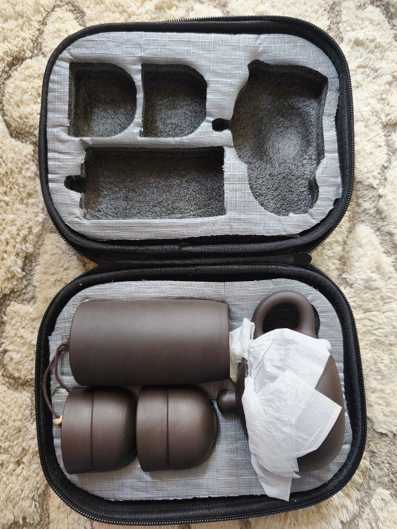 Portable Travel Tea Set (Category: Coffee & Tea Tableware) located in Davao. Submitted by dada_ahi (Listing ID 1392525089, Image 2). Description: Product: Portable Travel Tea Set, likely made from Yixing purple clay (Zisha). Contents: Typically includes a teapot, tea caddy (or storage for tea leaves), and multiple teacups, all neatly fitted into a compact carrying case. Features: Lightweight, small size, and durable, making it suitable for travel