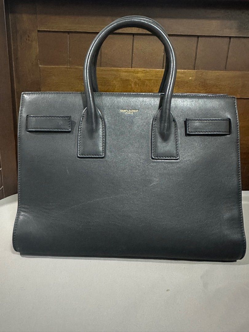 YSL Saint Laurent Sac De jour Small (Category: Luxury Bags & Wallets) located in Makati City. Submitted by rnathaliem (Listing ID 1392540411, Image 1). Description: YSL Saint Laurent Sac De jour Small 30 width 24 length Accordion style Black No strap (but i can include generic strap with gold hardware).