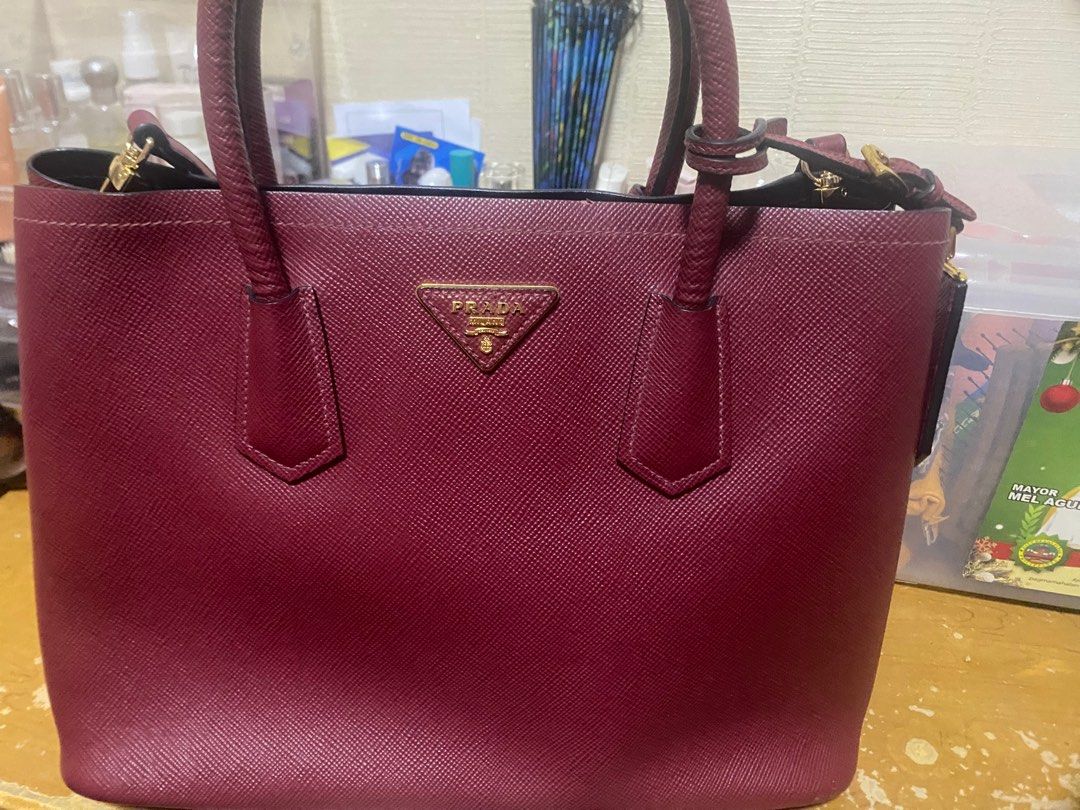Authentic Prada saffiano cuir leather double tote bag (Category: Luxury Bags & Wallets) located in Manila. Submitted by lodmallare85627 (Listing ID 1392792725, Image 1). Description: Seldom used though strap is no longer original but saffiano leather pa din which i bought frim a supplier. I lost the original strap kasi. Burgundy color super nice Lowered the price already fixed price authentic….very roomy can put a lot of things👌price is cheaper 
