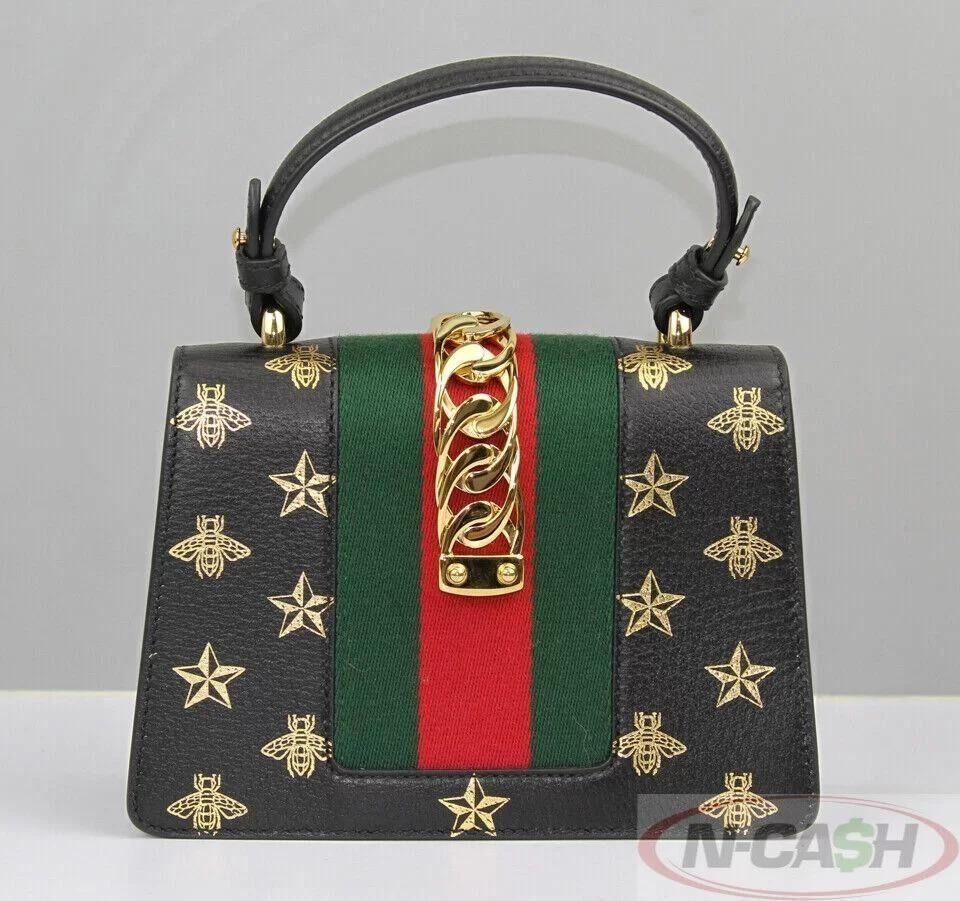 Gucci Sylvie Gold Bee Star Mini Black Leather Bag (Category: Luxury Bags & Wallets) located in Quezon City. Submitted by luxury_by_n-cash (Listing ID 1392969607, Image 2). Description: N-Cash Pawnshop "Instant Cash for Bags, Watches, Cars, and Electronics" https://www.ncash-pawnshop-philippines.com/ Gucci Sylvie Gold Bee Star Mini Black Leather Bag Measures: 8″ L x 5.5″ H x 3″ D (approx) 4″ Top Handle Drop 20″ Leather (adjustable) and Torchon Str