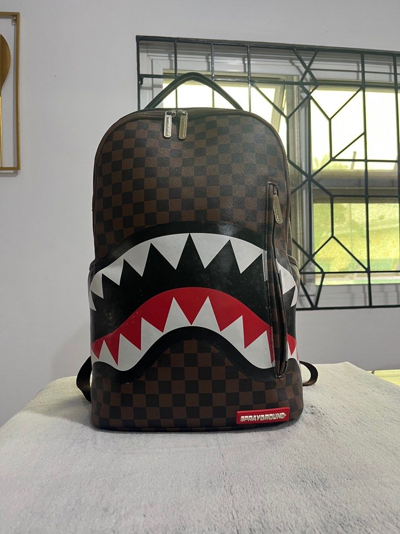 Sprayground Shark in Paris (brown) backpack (Category: Backpacks) located in Cabanatuan. Submitted by leonard0897 (Listing ID 1393187489, Image 1). Description: Selling preloved Sprayground Shark in Paris (brown) backpack PRODUCT DETAILS Exterior Dimensions: 18” x 6” x 11.5” • Front zipper pocket • Side pockets • Zippered Stash pocket • Separate velour sunglass compartment • Ergonomic mesh back padding • Adjustable Straps for custom sizing • Gold