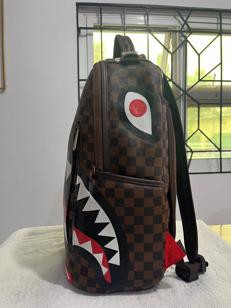 Sprayground Shark in Paris (brown) backpack (Category: Backpacks) located in Cabanatuan. Submitted by leonard0897 (Listing ID 1393187489, Image 2). Description: Selling preloved Sprayground Shark in Paris (brown) backpack PRODUCT DETAILS Exterior Dimensions: 18” x 6” x 11.5” • Front zipper pocket • Side pockets • Zippered Stash pocket • Separate velour sunglass compartment • Ergonomic mesh back padding • Adjustable Straps for custom sizing • Gold