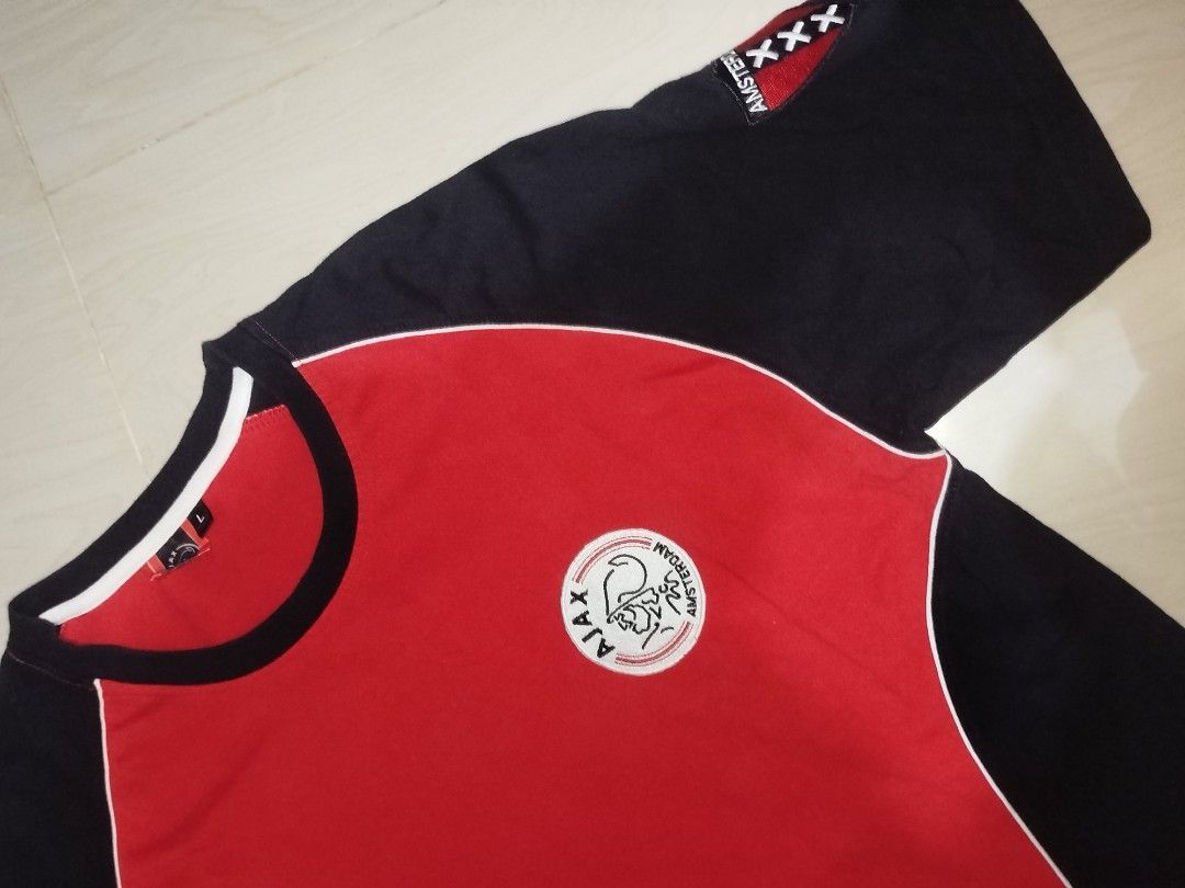 Ajax Amsterdam T-shirt - Size L (Category: Tshirts & Polo Shirts ) located in Manila. Submitted by yanskiezco (Listing ID 1393279632, Image 2). Description: - Ajax Amsterdam T-shirt - Size: L - Color scheme: Red and black - Features the Ajax logo on the front - Back design: "Amsterdam" and "Ajax" - Design: Round neck, short sleeves - Details: White trim around the neck and sides.
