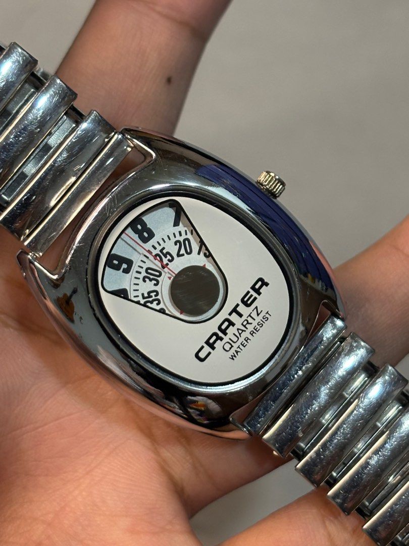 Crater Quartz Jump Hour Watch (Category: Men's Watches) located in Manila. Submitted by soughtafterseconds (Listing ID 1393395266, Image 2). Description: Crater Quartz Jump Hour Watch This is a Crater Quartz Jump Hour Watch, a retro-styled timepiece that uses a digital mechanical display instead of traditional hands. The top two windows display the hours and minutes, while the lower rotating disc shows the seconds. This jump hour design mimics th