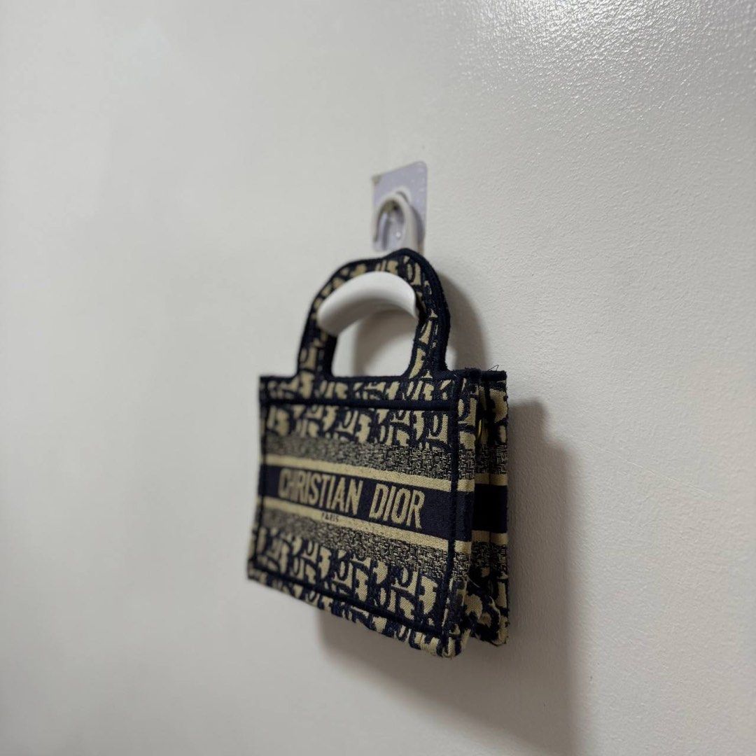 Mini Dior Book Tote Bag (Category: Luxury Bags & Wallets) located in Angeles City. Submitted by cherrypicked.ph (Listing ID 1393413051, Image 3). Description: Mini Dior Book Tote Bag 📌 Width: 9" Height: 6" Depth: 1.5" Handle: 10" Condition: 9/10 Issue: Missing Sling 🧷 Price: 1500 + sf 📍 Angeles City, Pampanga 🚛 Courier – J&T (Regular Shipping).
