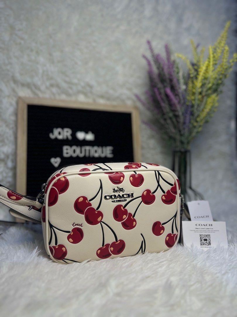 Coach Mini Jamie Camera Bag w/ Cherry Print (Category: Luxury Bags & Wallets) located in Tarlac. Submitted by lassyjackie (Listing ID 1390302339, Image 2). Description: ON HAND | BRAND NEW | AUTHENTIC From Canada 🇨🇦🍁 Negotiable Price Mode Of Payment: gcash or bpi Mode Of Delivery: lbc or jnt Design: Crafted from refined pebble leather with a cherry print, it’s a compact camera bag style. Features: It includes an adjustable strap for shoulder o