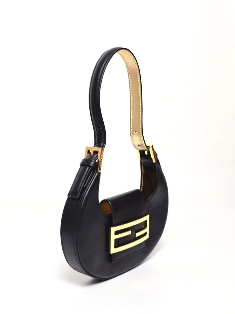 Fendi Black Mini Cookie Hobo Bag (Category: Luxury Bags & Wallets) located in Pandi. Submitted by luximperium (Listing ID 1393623964, Image 1). Description: Color: Black Includes: Dust bag Material: Calfskin Leather Size: Small Dimensions: L (21cm), H (12.5cm), W (2.6cm), HD (20cm—adjustable) Closure & Pockets: Flap closure with magnetic snap Hardware: Gold-tone Condition: Pristine Others: Lining and under strap feature gold leather detail.