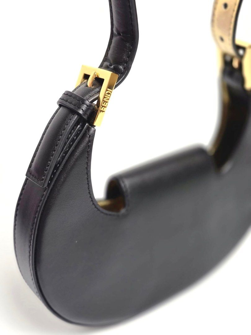 Fendi Black Mini Cookie Hobo Bag (Category: Luxury Bags & Wallets) located in Pandi. Submitted by luximperium (Listing ID 1393623964, Image 2). Description: Color: Black Includes: Dust bag Material: Calfskin Leather Size: Small Dimensions: L (21cm), H (12.5cm), W (2.6cm), HD (20cm—adjustable) Closure & Pockets: Flap closure with magnetic snap Hardware: Gold-tone Condition: Pristine Others: Lining and under strap feature gold leather detail.