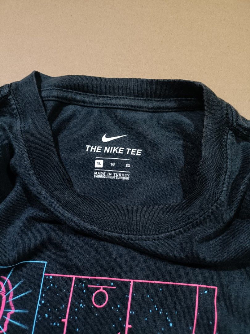 Nike The Nike Tee XL (Category: Tshirts & Polo Shirts ) located in Quezon City. Submitted by selectorsthrift (Listing ID 1393728775, Image 2). Description: - Black Nike T-shirt - Size: XL - Features a basketball court graphic with "JUST DO IT" print - Nike logo on chest - Crew neck - Made in Turkey - Graphic includes pink and blue accents.