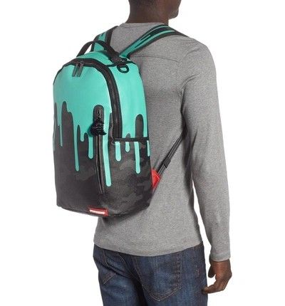 Sprayground Drip Camo Backpack (Category: Backpacks) located in Manila. Submitted by renzmalacc07450 (Listing ID 1393621571, Image 3). Description: Sprayground Tiff Drip Camo Teal Leather bought in middle east leather may mga issue na kit naman s pic baliwag bulacan 1800 - Sprayground backpack with unique drip camo design. - Teal top with black drips over a camouflage pattern. - Features multiple zippered compartments and side pockets. - Includes