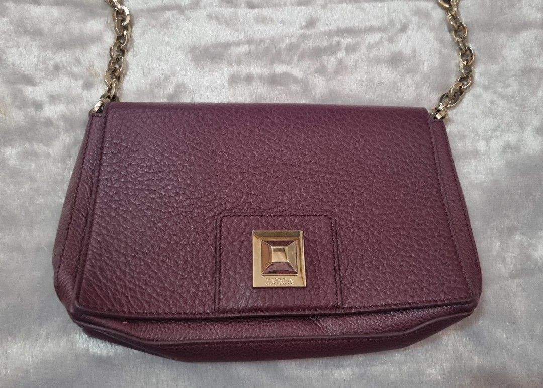 Furla Sling Bag (Category: Luxury Bags & Wallets) located in Davao. Submitted by noona.nette (Listing ID 1393981568, Image 3). Description: - Furla shoulder bag - Rich burgundy color - Gold-tone square clasp - Chain strap - Includes dust bag and tags - Interior zippered pocket - Furla leather tag - Made of genuine leather - Perfect for everyday or special occasions.