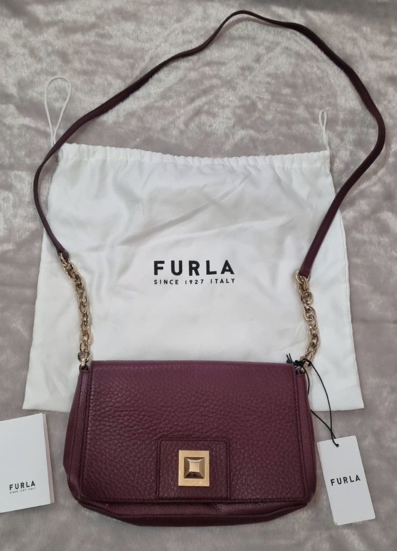 Furla Sling Bag (Category: Luxury Bags & Wallets) located in Davao. Submitted by noona.nette (Listing ID 1393981568, Image 1). Description: - Furla shoulder bag - Rich burgundy color - Gold-tone square clasp - Chain strap - Includes dust bag and tags - Interior zippered pocket - Furla leather tag - Made of genuine leather - Perfect for everyday or special occasions.