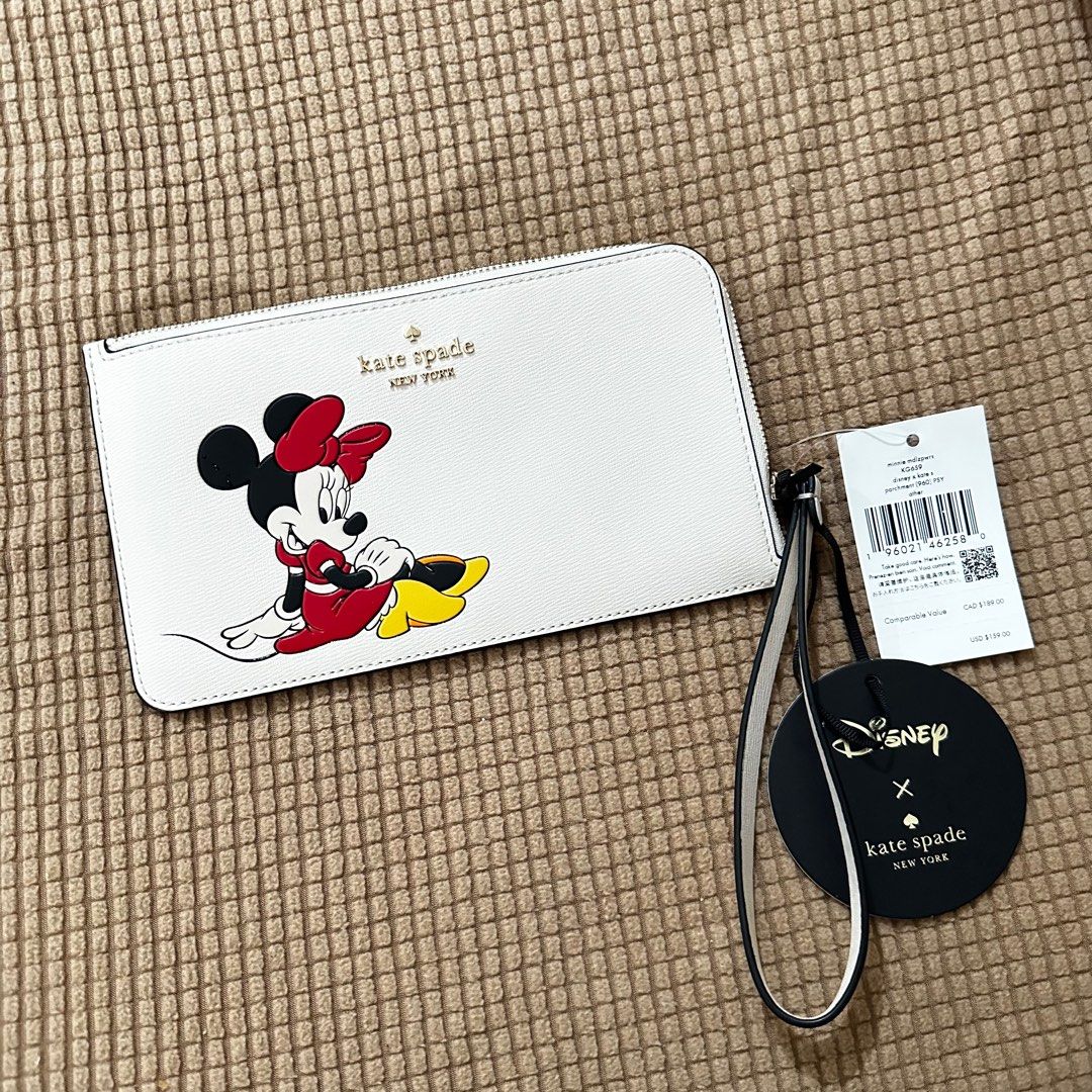 Kate Spade Wristlet (Category: Wallets & Card holders) located in Las Pinas. Submitted by apdeclutter (Listing ID 1393829253, Image 2). Description: The Kate Spade Medium L-Zip Wristlet Disney X Kate Spade New York Minnie is a stylish clutch designed in collaboration with Disney. Made of PVC material with an exterior color of Parchment Multi, this medium-sized wristlet features a zip closure and is adorned with a cute Minnie Mouse design. Perfect