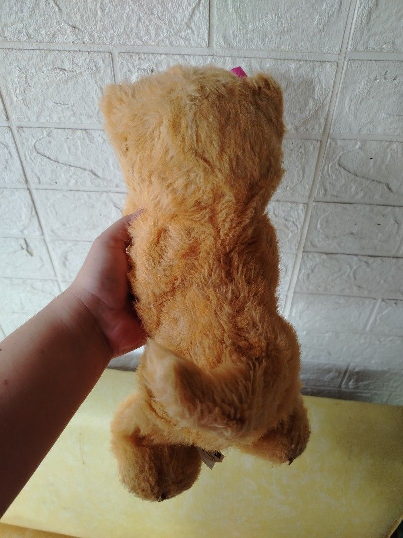 Orange Cat Plush Toy Furreal (Category: Plushies & Soft Toys) located in Tayasan. Submitted by _raceprettyconcept (Listing ID 1393821820, Image 2). Description: - Adorable orange cat plush toy - Comes with a sweet pink bow - Features a soft white chest and paws - Includes a battery compartment ( walang takip ang isang bat compartment) (batteries not included).