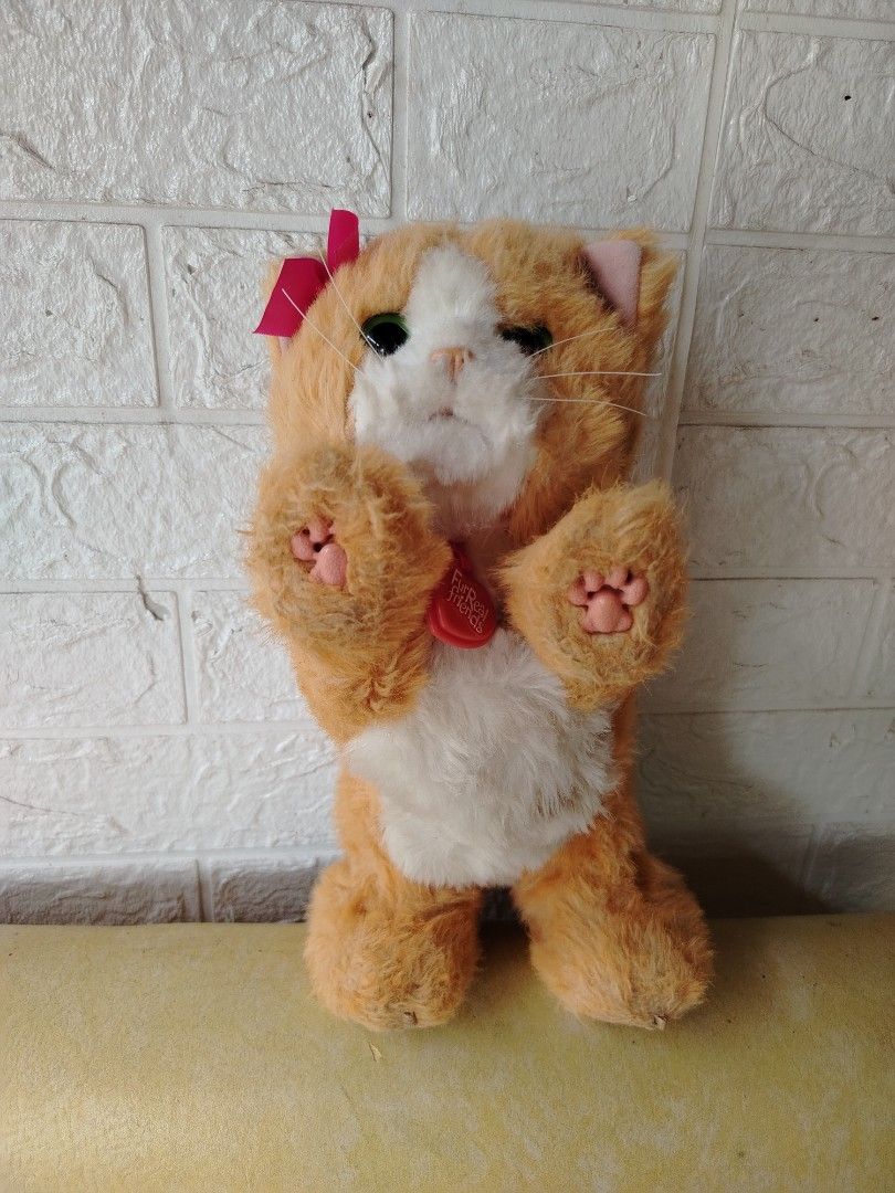 Orange Cat Plush Toy Furreal (Category: Plushies & Soft Toys) located in Tayasan. Submitted by _raceprettyconcept (Listing ID 1393821820, Image 1). Description: - Adorable orange cat plush toy - Comes with a sweet pink bow - Features a soft white chest and paws - Includes a battery compartment ( walang takip ang isang bat compartment) (batteries not included).