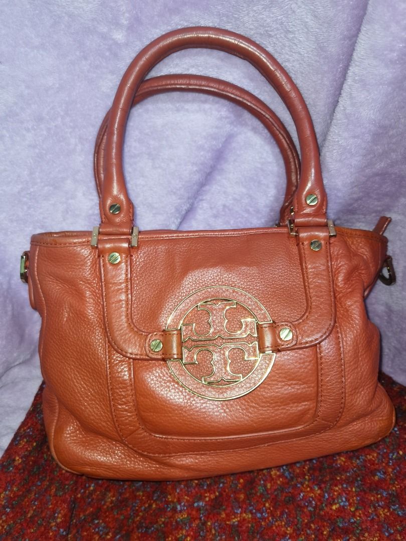 Tory Burch Amanda Satchel Leather Handbag (Category: Luxury Bags & Wallets) located in Caloocan City. Submitted by lux_sellier (Listing ID 1394101499, Image 2). Description: - Authentic Tory Burch handbag - Genuine leather - Top handle design - Prominent logo detail - Zip closure - Interior pocket - Gold-toned hardware - Textured leather - Reddish orangey color 9.5/10 condition.