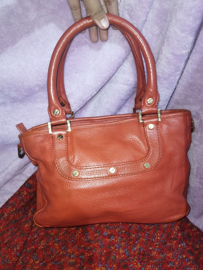 Tory Burch Amanda Satchel Leather Handbag (Category: Luxury Bags & Wallets) located in Caloocan City. Submitted by lux_sellier (Listing ID 1394101499, Image 3). Description: - Authentic Tory Burch handbag - Genuine leather - Top handle design - Prominent logo detail - Zip closure - Interior pocket - Gold-toned hardware - Textured leather - Reddish orangey color 9.5/10 condition.