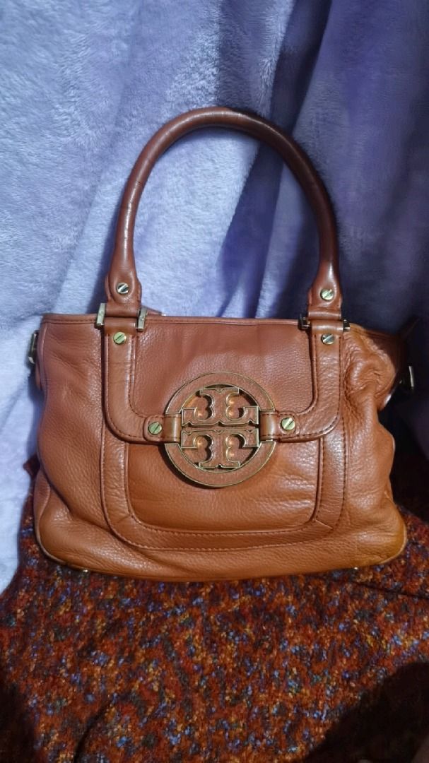 Tory Burch Amanda Satchel Leather Handbag (Category: Luxury Bags & Wallets) located in Caloocan City. Submitted by lux_sellier (Listing ID 1394101499, Image 1). Description: - Authentic Tory Burch handbag - Genuine leather - Top handle design - Prominent logo detail - Zip closure - Interior pocket - Gold-toned hardware - Textured leather - Reddish orangey color 9.5/10 condition.