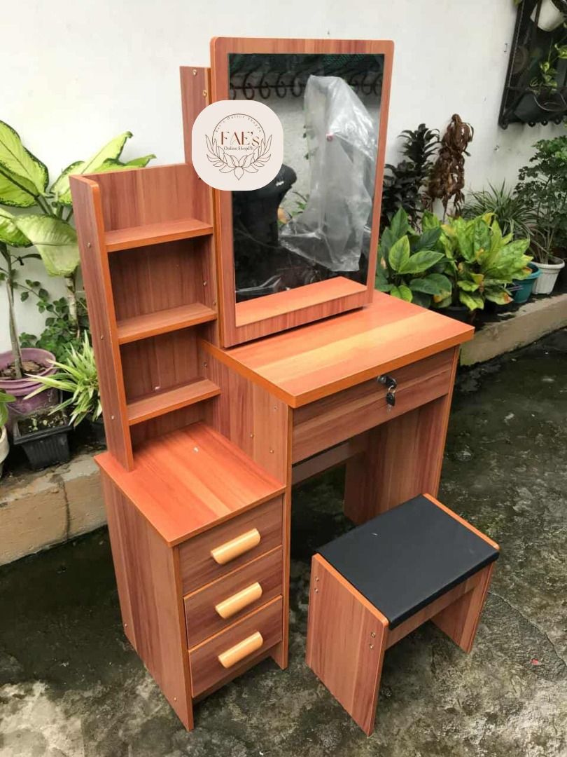 Wooden Vanity Table with Mirror and Stool (Category: Tables & Sets) located in Cavite. Submitted by faelejarde (Listing ID 1394075580, Image 2). Description: - Wooden vanity table with mirror - Features three drawers for storage - Includes a lockable drawer for security - Additional side shelf for extra storage - Comes with a small stool - Stool has a black seat - Made of wood with a warm brown finish.