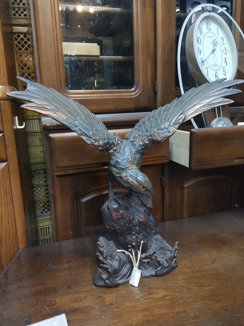 Bronze Eagle Sculpture (Category: Figurines & Statues) located in Manila. Submitted by tonisfurnitureshop (Listing ID 1394321105, Image 1). Description: - Bronze eagle sculpture - Outstretched wings - Perched on a rocky base - Detailed design - Weathered appearance - Dark brown and green patina - Decorative piece.