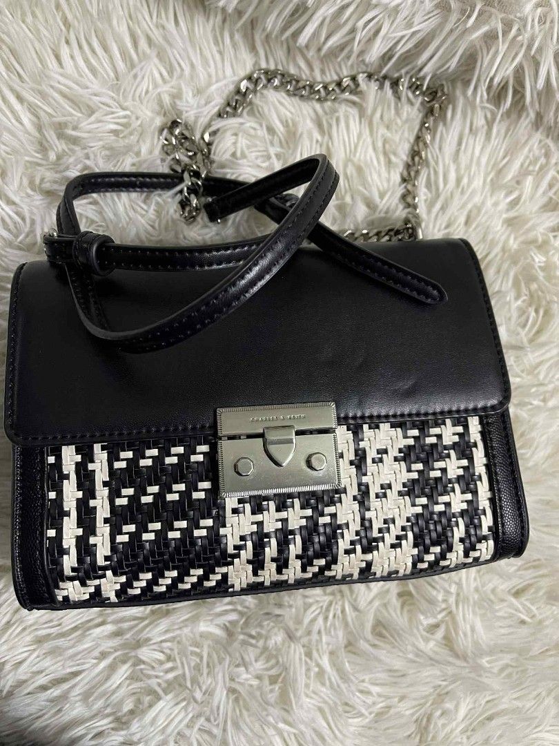Charles & Keith Black and White Handbag (Category: Luxury Bags & Wallets) located in Santa Rosa. Submitted by zeanncloset (Listing ID 1394212882, Image 3). Description: - Charles & Keith Sling Chained Sling bag - Black and white design - Woven front panel - Black leather top - Silver chain strap - Silver clasp closure - Pink interior - Small back pocket - Approximately 7 inches wide.