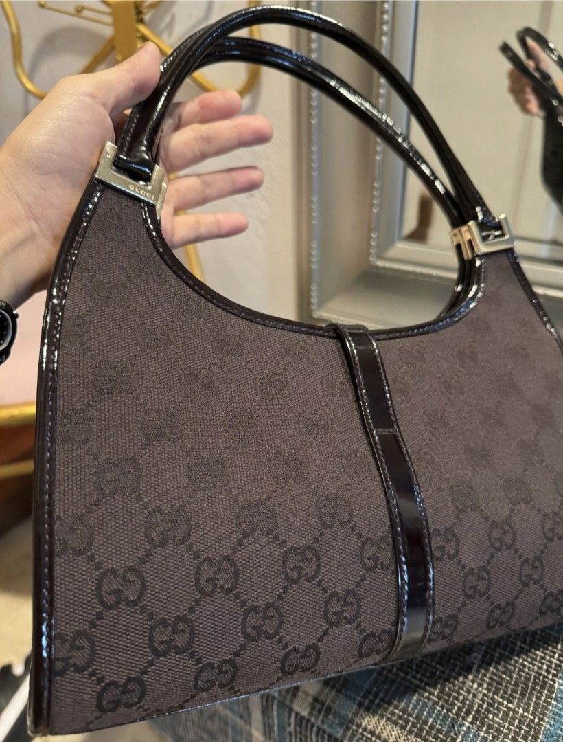 Gucci Jackie Bag (Category: Luxury Bags & Wallets) located in Manila. Submitted by dulce.yap (Listing ID 1394304838, Image 3). Description: - Authentic rare Gucci Jackie bag comes with dust bag and care card - chocolate brown - Iconic GG monogram canvas - Patent leather trim and handle - Top handle design - Flap closure with gold-tone clasp - Fabric lining with zippered pocket - Serial number: 002-1068 001013.