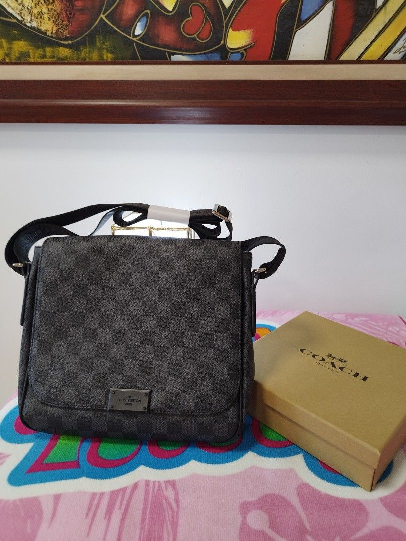 Louis Vuitton Damier Graphite Messenger Bag (Category: Luxury Bags & Wallets) located in Manila. Submitted by grimisa20056430 (Listing ID 1394326314, Image 1). Description: - Mirror copy Louis Vuitton Damier Graphite messenger bag. - Features the classic checkered Damier Graphite pattern. - Adjustable black strap for comfortable wear. - Includes a small metal Louis Vuitton logo plaque. - The interior features a black lining and a leather tag that