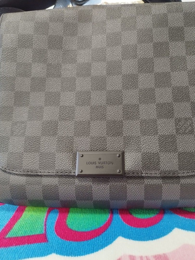 Louis Vuitton Damier Graphite Messenger Bag (Category: Luxury Bags & Wallets) located in Manila. Submitted by grimisa20056430 (Listing ID 1394326314, Image 2). Description: - Mirror copy Louis Vuitton Damier Graphite messenger bag. - Features the classic checkered Damier Graphite pattern. - Adjustable black strap for comfortable wear. - Includes a small metal Louis Vuitton logo plaque. - The interior features a black lining and a leather tag that
