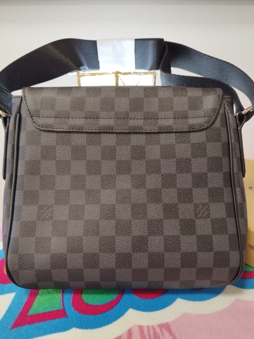 Louis Vuitton Damier Graphite Messenger Bag (Category: Luxury Bags & Wallets) located in Manila. Submitted by grimisa20056430 (Listing ID 1394326314, Image 3). Description: - Mirror copy Louis Vuitton Damier Graphite messenger bag. - Features the classic checkered Damier Graphite pattern. - Adjustable black strap for comfortable wear. - Includes a small metal Louis Vuitton logo plaque. - The interior features a black lining and a leather tag that