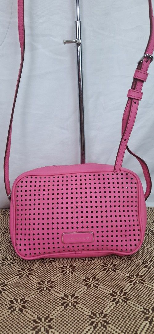 Marc by Marc Jacobs Perforated Crossbody Bag (Category: Luxury Bags & Wallets) located in Baguio. Submitted by rhaizen_ukay (Listing ID 1394220711, Image 2). Description: - Pink Marc by Marc Jacobs crossbody bag - Perforated design - Zip closure - Long strap for shoulder/crossbody wear - Pink interior with small pocket - Metal zipper and hardware.