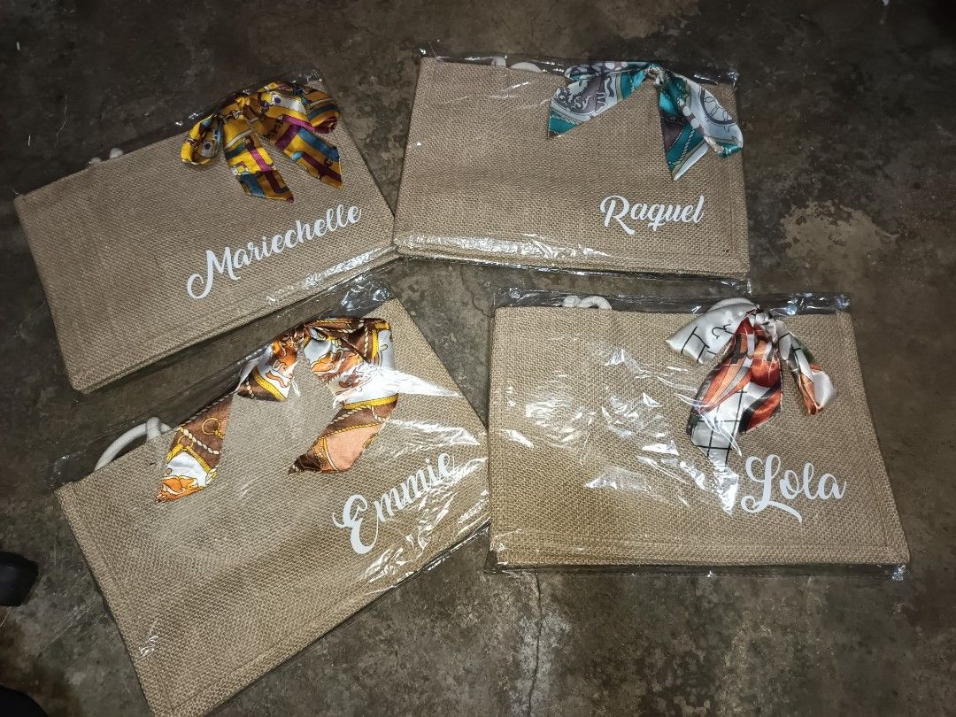 Personalized Jute Tote Bag with Scarf (Category: Tote Bags) located in Caloocan City. Submitted by maribelsb (Listing ID 1394221754, Image 3). Description: Stylish jute tote bags, perfect for everyday use or as a personalized gift. Each bag features a unique name and a decorative scarf tied to the handle. Great for carrying essentials in style..