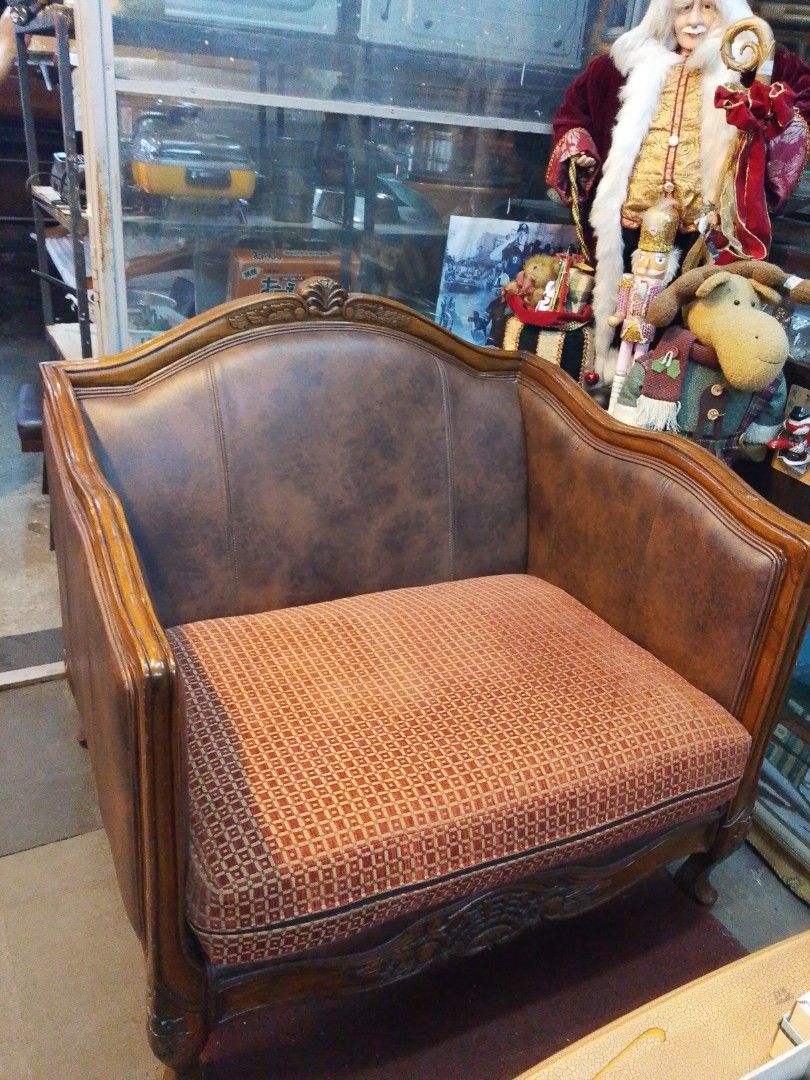 Vintage Wooden Sofa (Category: Sofas) located in Manila. Submitted by tonisfurnitureshop (Listing ID 1394345337, Image 1). Description: - Vintage sofa - Wooden frame with carvings - Brown leather back and sides - Patterned orange cushion - Classic design - Well-constructed - Ideal for living room or lounge.