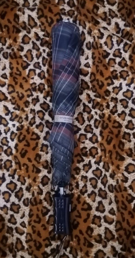 Givenchy Plaid Umbrella (Category: Umbrellas) located in Cebu City. Submitted by roadthrift (Listing ID 1394406329, Image 1). Description: - Givenchy plaid umbrella - Classic plaid pattern in blue, green, and red - Black handle with Givenchy logo - Folds up for easy storage - Givenchy logo on the interior - Stylish accessory for rainy days.