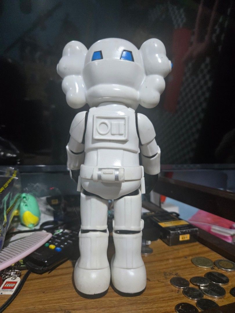 KAWS Stormtrooper Figure (Category: Figurines & Statues) located in Manila. Submitted by ritzselect26 (Listing ID 1394432073, Image 2). Description: - KAWS Stormtrooper figure - Features KAWS signature design - Iconic X eyes and hands - Color: White with black accents and blue eyes - Marked with "Designed by KAWS" - Marked with "MEDICOMTOY 2006 CHINA".